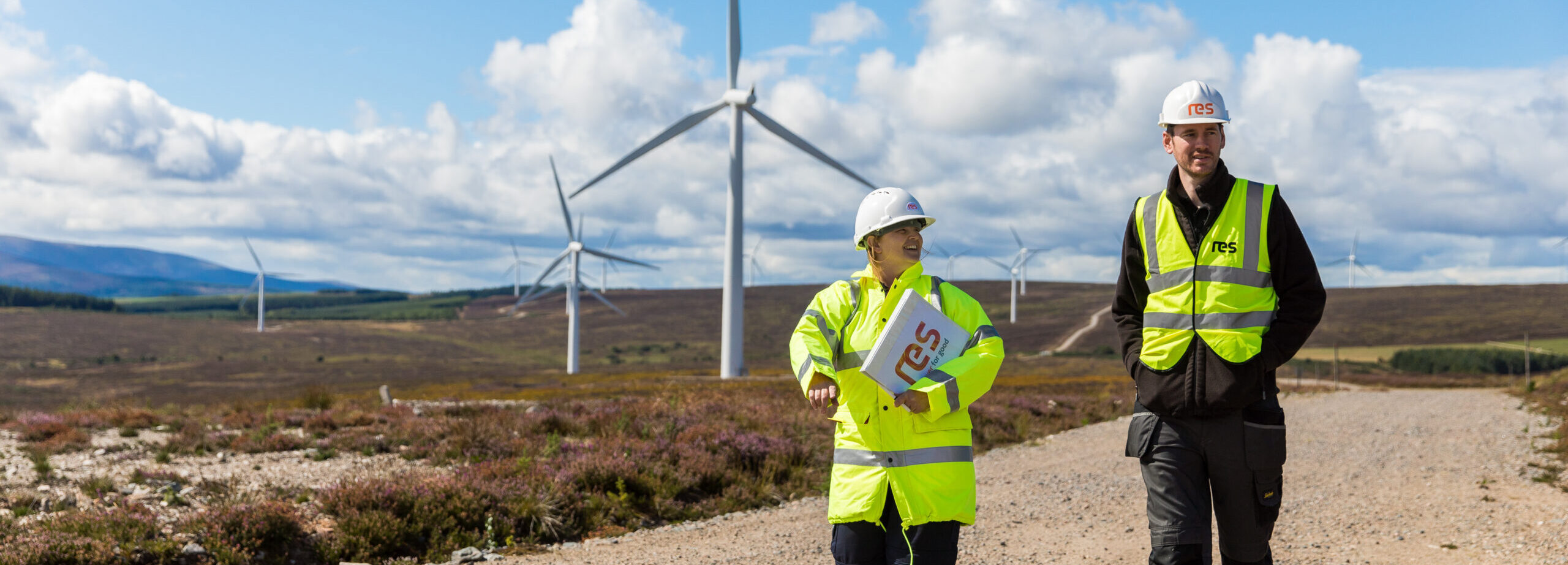 People talking in front of wind turbines