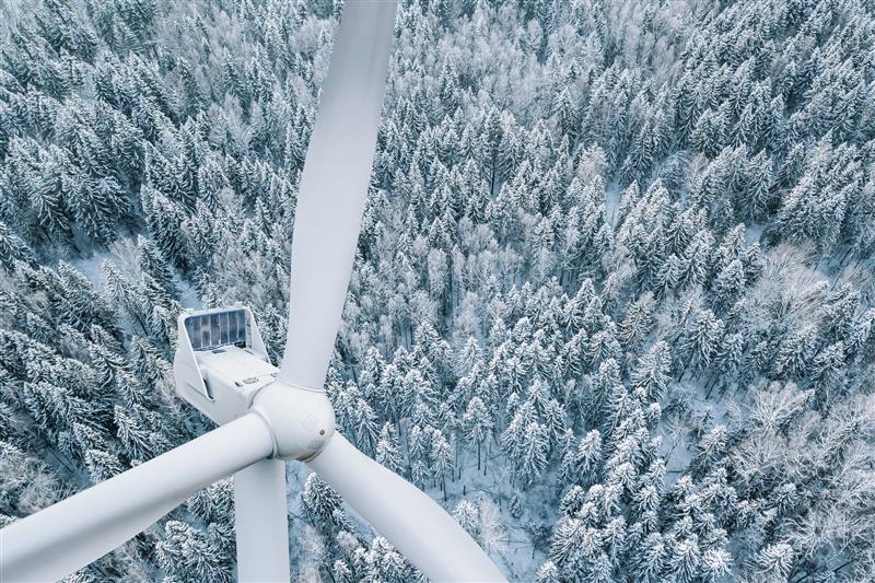 Wind turbine with snowy backdrop